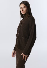 Bruine wolmix cardigan met een gestructureerd oppervlak, ribbenmanchetten, decoratieve knopen, twee voorzakken en een geborduurd logo.