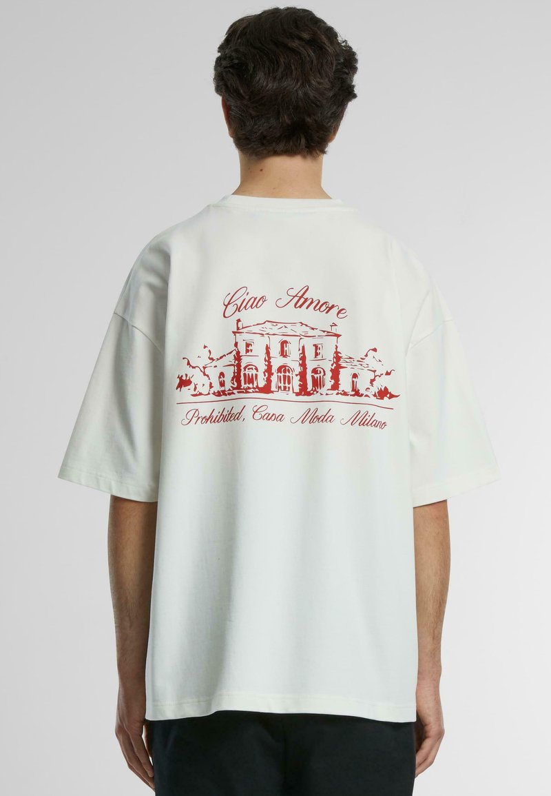 Tricou alb din bumbac cu un design grafic roșu pe spate, reprezentând o clădire și textul "Ciao Amore" și "Interzis, Casa Moda Milano."