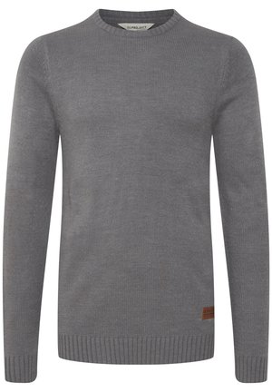 Szary sweter o prążkowanej strukturze, okrągłym dekolcie i długich rękawach. Posiada brązową skórzaną naszywkę z logotypem na dolnej części.