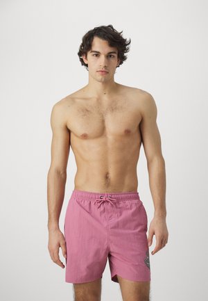 Bañador rosa con una cinturilla elástica y cordón. Presenta una textura sutil y un pequeño acento bordado en el lateral.