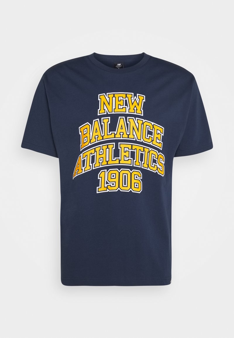 Námořnická modrá bavlněná tričko s výrazným žlutým textem: "NEW BALANCE ATHLETICS 1906" v obloukovém designu. Kulatý límec a krátké rukávy.