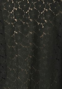 Tecido de renda preta com padrão floral, apresentando tamanhos variados de formas de flores, textura transparente e detalhes intrincados ao longo das bordas.