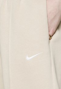 Nike Sportswear W NSW ESSNTL PANT FLC TREND - Calças de fato de treino - sanddrift/white
