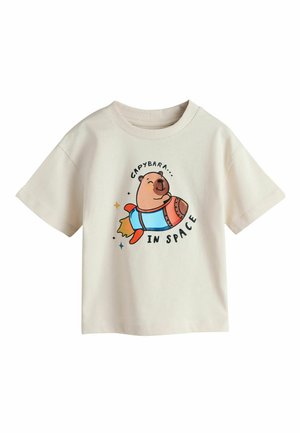 Kremowa koszulka z krótkim rękawem z uśmiechniętą kapibarą jadącą na rakiecie, z napisem „Capybara w kosmosie” wokół ilustracji.