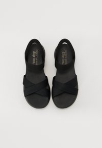 Fekete szandál, keresztbe futó elasztikus hevederekkel, slip-on kialakítással és texturált talppal. Az alsó része lapos és sima.