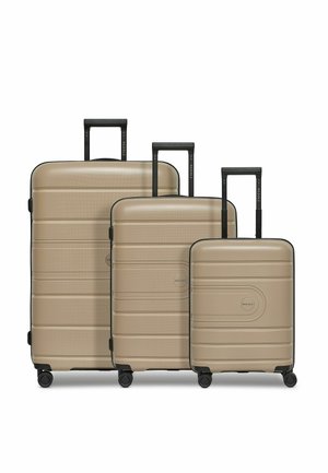 Drie harde koffers in een metallic goudkleur. Ze hebben een textuuroppervlak, zwarte handvatten en wielen voor mobiliteit, en variëren in grootte.