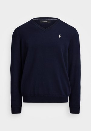 Granatowy sweter z długim rękawem w kształcie V, z małym białym haftowanym logo gracza polo po lewej stronie klatki piersiowej.