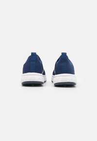 Marinblåa träningsskor med ett texturerat mesh-övre, en vadderad vit mellanläggssula och en gummiyttersula. Har en dragflik vid hälen.
