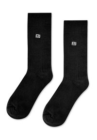 Czarne bawełniane skarpetki o prążkowanej fakturze, z małym białym logo po zewnętrznej stronie oraz tradycyjną długością typu crew.