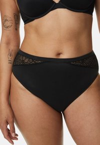 Zwarte high-waisted onderbroeken van gladde stof met bloemige kantaccenten bij de tailleband, met een naadloze afwerking en gematigde bedekking.