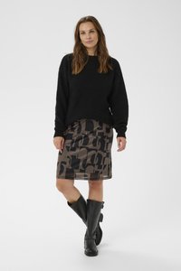 Sort strikket sweater, mønstret nederdel med mørke logoer og knæhøje sorte støvler. Har afslappet pasform og glatte teksturer.
