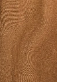 Bronzen gestructureerde stof met een gladde, geweven uitstraling, gekenmerkt door subtiele variaties in tint en korrelpatronen.