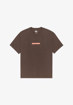 Camiseta de algodón marrón con mangas cortas y cuello redondo. Presenta un logo de "Quiksilver" en rojo y blanco en el centro. Textura suave.