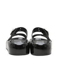 Sandales à plateforme noires avec brides réglables à la cheville et bords arrondis, vues de dos sur fond blanc.