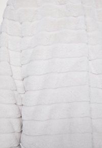 Faux kožíšková bunda v jemně šedé barvě, s propleteným vlnitým vzorem. Měkký, plyšový materiál s útulným vzhledem, navržený pro teplo.