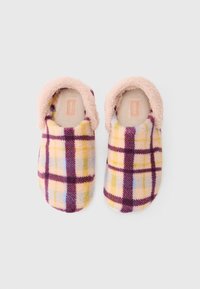 Pāris pūkainu slip-on čībiņu ar pasteļdzeltenu, purpura un gaiši zilu šķērsojumu, kā arī mīkstu rozā zamšādu oderi uz baltā fona.