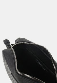 Borsa in pelle nera con esterno testurizzato e cerniera argentata. L'interno è foderato in tessuto nero. Presenta un'etichetta del marchio all'interno.