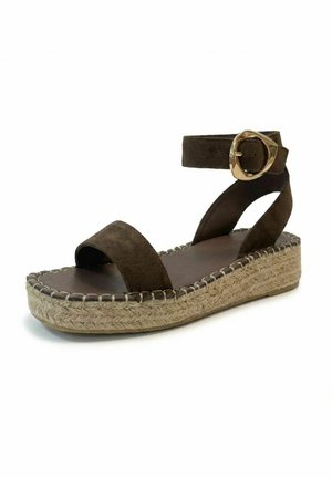 Sandale plateforme en daim marron avec bride cheville, grosse boucle dorée, bout ouvert et semelle en jute tressé, isolée sur fond blanc.