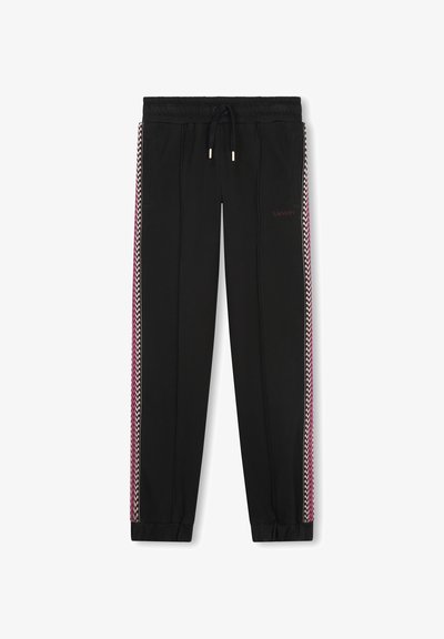 Pantalons de jogging noirs avec une taille à cordon, ornés de rayures en zigzag roses et blanches sur les côtés et de poignets élastiques aux chevilles.