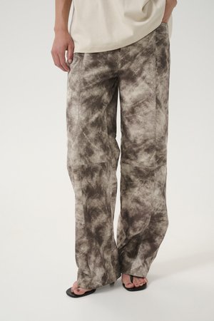 Pantalones de pierna ancha en un tejido suave y texturizado que presenta un patrón abstracto en marrón y crema. Terminado con costuras sutiles y un ajuste relajado.