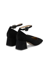 Scarpe nere in suede con tacco a blocco e punta affusolata, cinturino alla caviglia con una chiusura decorativa e finitura testurizzata sul materiale superiore.