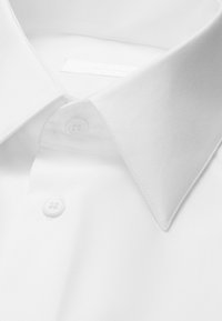 Camicia bianca con collo appuntito e due bottoni visibili sulla patta frontale.