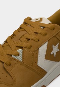 Καφέ αθλητικό παπούτσι από συνθετικό σουέντ με λογότυπο λευκό αστέρι και διακοσμητικά στοιχεία. Διαθέτει επίπεδα κορδόνια και υφή με λεπτομέρειες στο πάνω μέρος.