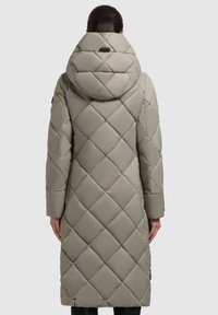 Cappotto lungo, imbottito e trapuntato in grigio chiaro con cappuccio. Presenta cuciture diagonali, chiusura con zip e tasche laterali. Texture liscia e imbottita.