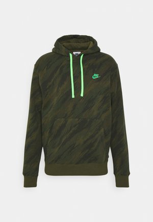 Ciemnozielona bluza z kapturem Nike w kamuflażu z neonowo zielonymi sznurkami, przednią kieszenią na brzuchu i małym logo Nike po lewej stronie klatki piersiowej.