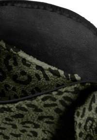 Fleece deken met een zwarte achterkant en een olijfgroene voorkant met luipaardprint. Kenmerkt zich door een zachte textuur en gestikte randen.