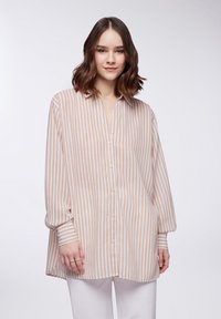 Camicia a righe in toni beige e bianco, con una vestibilità rilassata, maniche lunghe e una texture morbida e leggera.