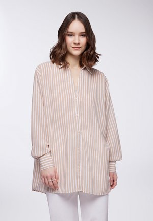 Camicia a righe in toni beige e bianco, con una vestibilità rilassata, maniche lunghe e una texture morbida e leggera.