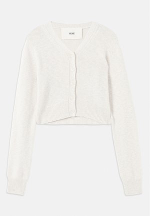 Skórzany kardigan o kroju slim z dekoltem w serek, z zapięciem na guziki i prążkowanymi mankietami. Wykonany z miękkiego dzianiny o delikatnej fakturze.