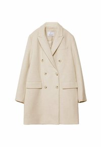 Beige dobbeltknappet frakke lavet af tekstureret stof, med nappekraver, to forlommer og to knapper på hver side.
