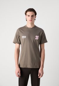 Olive green cotton t-shirt with a crew neck, featuring white text "DENTAL MYSTERY" and a pink floral graphic on the left side.