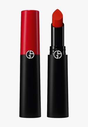 Produit à lèvres avec un capuchon rouge et une base noire. Le bâton est d'un rouge mat avec une pointe. Présente un logo argenté sur le capuchon.