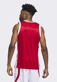 Rotes ärmelloses Basketball-Trikot mit weißen Akzenten, aus atmungsaktivem Material gefertigt. Verfügt über einen runden Ausschnitt und ein sportliches Schnittdesign.