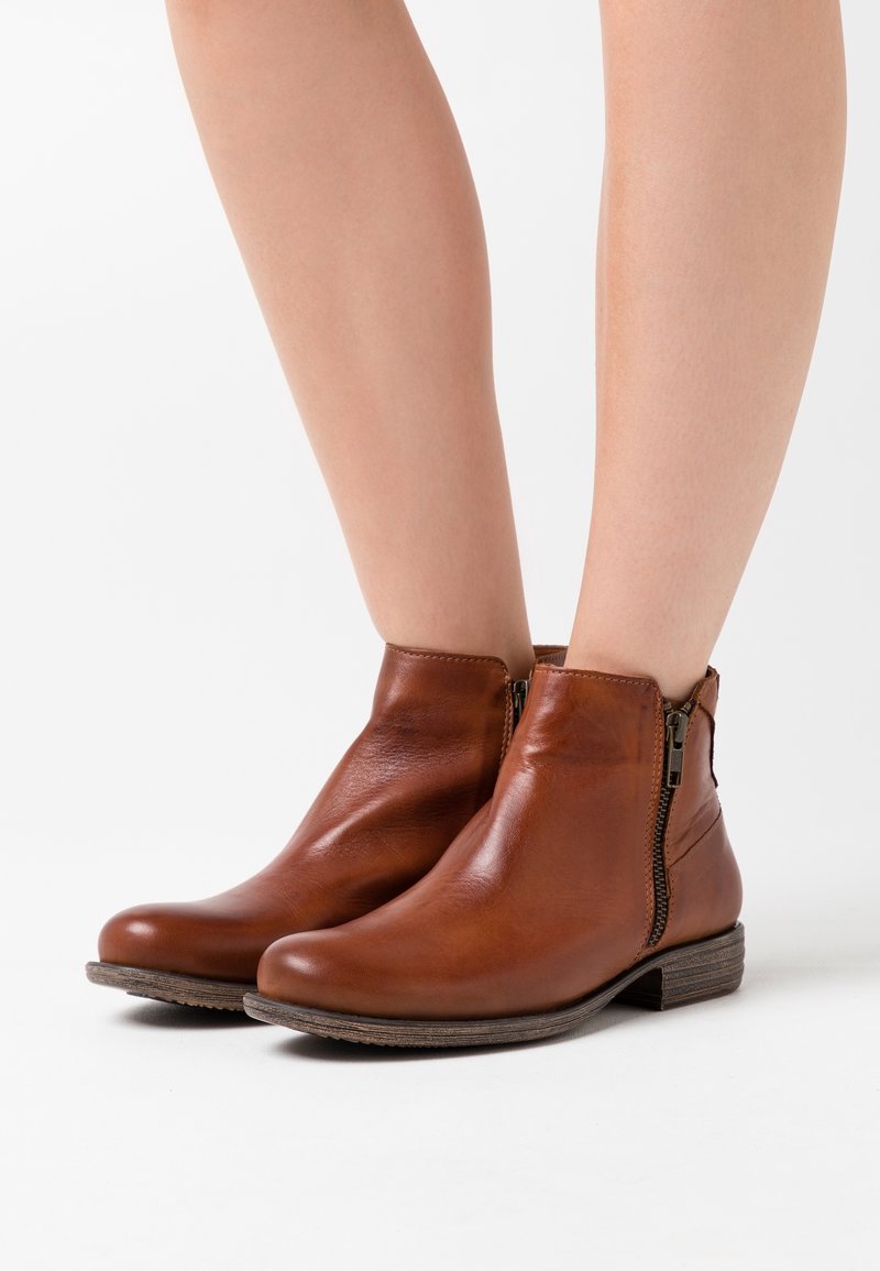 Bottes mollet en cuir marron à texture lisse, fermeture éclair latérale, bout arrondi et accent en bois sur la semelle.