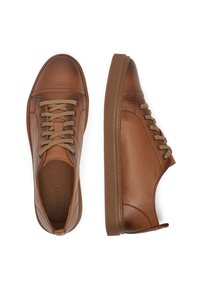 Zapatillas de cuero marrón con bajo perfil, con puntera redonda, cordones beige y suela de goma texturizada. Diseño minimalista, sin marcas visibles.