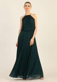 Plissiertes türkisfarbenes Maxikleid mit Halterneck und mit Perlen besetzten Trägern, das ein fließendes Design und eine glatte Textur aufweist und bis zu den Knöcheln reicht.