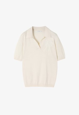 Kremo spalvos trumpomis rankovėmis polo marškiniai su minkšta tekstūra, su subtiliu siuvinėtų raštu kairėje krūtinės pusėje ir klasikiniu apykakle.