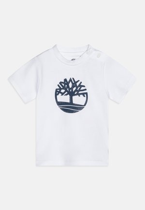 T-shirt blanc à manches courtes en coton, avec un graphisme d'arbre bleu marine en design circulaire à l'avant. Comprend des pressions aux épaules.