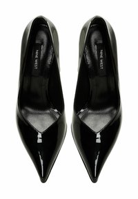 Juodos lakuotos odos aukštakulniai su smailiu pirštu ir V formos išpjova priekyje. Lygus paviršius ir minimalizmas dizainas. Prekės ženklas: Nine West.