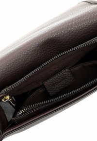 Braune Lederhandtasche mit Reißverschlussfächern im Inneren. Merkmale sind die strukturierte Oberfläche, das Stofffutter und die goldenen Hardware-Akzente.