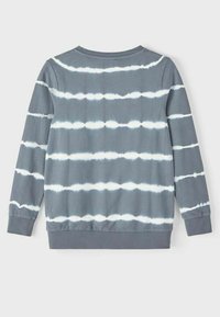 Felpa grigia tie-dye con strisce bianche orizzontali. Presenta un collo rotondo e polsini a coste, realizzata in morbido materiale di cotone.