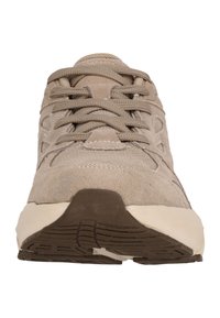 Beige mokkasiner i semsket skinn med strukturert overflate, rund tå og flat, mønstrete brun gummi såle. Har snørebånd og sidedrag for ventilasjon.