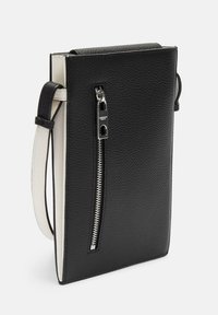Black leather crossbody bag with textured surface, contrasting cream interior, silver zipper detail, and sleek rectangular shape.