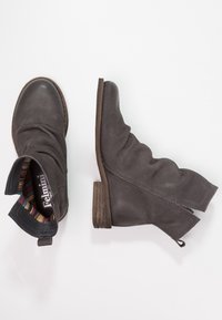 Bottines grises en cuir texturé, avec un petit talon en bois et une doublure à rayures colorées, dotées de côtés élastiques pour un enfilage facile.