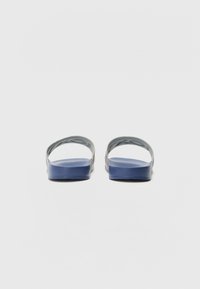 Blå sklidesandaler med en glat, flad sål og to grå stropper. Designet er minimalistisk med en tekstureret overdel for bedre greb.