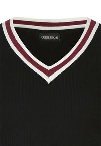 Top in maglina a coste nera con scollatura a V. Il colletto presenta strisce bianche e bordeaux. L'etichetta riporta la scritta "GUESS JEANS."